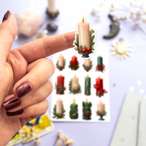 May include: A sheet of stickers featuring twelve illustrated candles with holly and berries. The candles are in various colors, including red, green, and white.