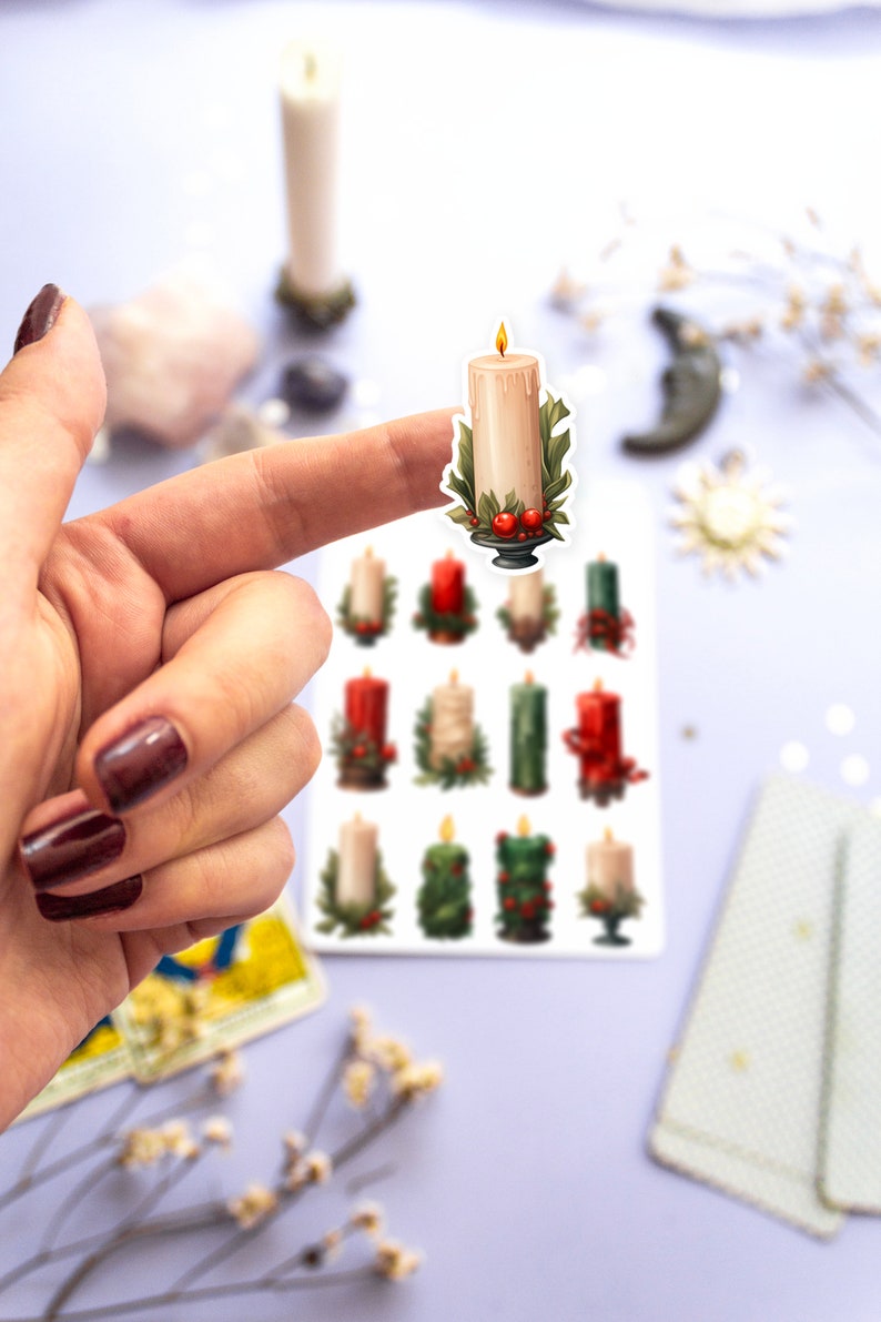 May include: A sheet of stickers featuring twelve illustrated candles with holly and berries. The candles are in various colors, including red, green, and white.