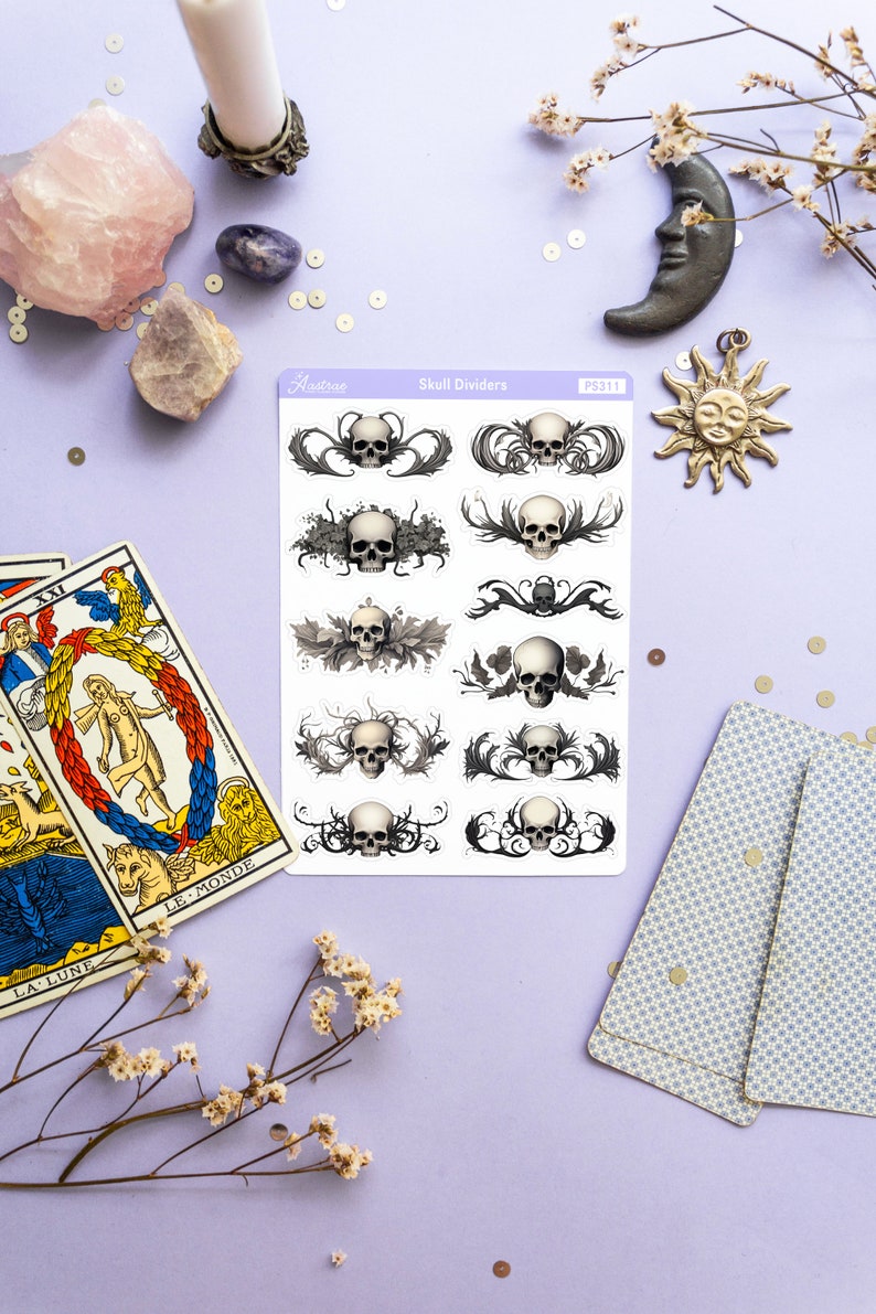 May include: A sheet of skull divider stickers with a white background and black and gray skulls with ornate designs. The sheet is labeled "Skull Dividers" and "PS311".