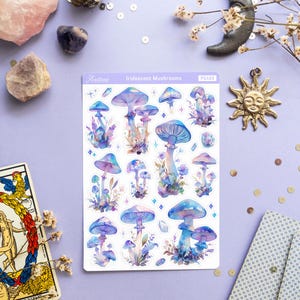Puede incluir: Una hoja de pegatinas de setas iridiscentes con fondo blanco. Las pegatinas presentan varias setas azules y moradas con puntos blancos y detalles de purpurina. La hoja est&aacute; etiquetada como "Iridescent Mushrooms" y "PS465".
