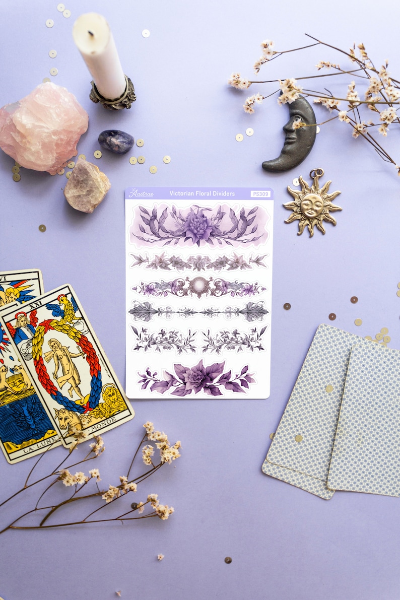 Peut inclure: Une feuille de s&eacute;parateurs floraux victoriens violets et blancs avec le texte "Victorian Floral Dividers" et "PS309" sur un fond violet avec des cartes de tarot, un cristal, une bougie et un charme de lune et de soleil.