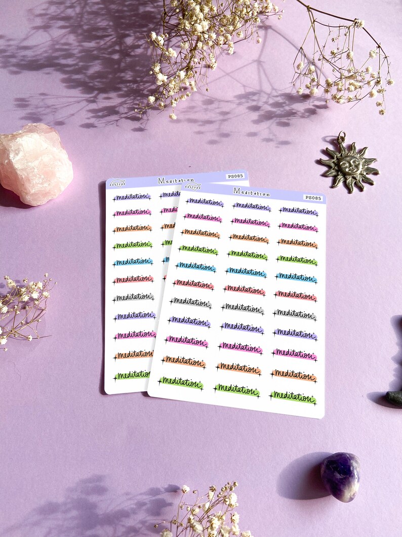 May include: Three sheets of stickers with the word "meditation" written in different colors and fonts. The stickers are on a purple background.