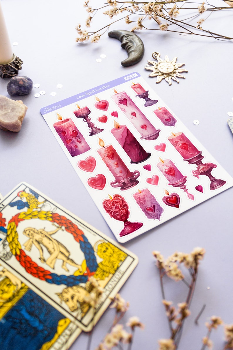 Pode incluir: Uma folha de adesivos com ilustra&ccedil;&otilde;es de velas de feiti&ccedil;o de amor rosa e roxas com cora&ccedil;&otilde;es. Os adesivos est&atilde;o em um fundo roxo claro. O texto "Love Spell Candles" est&aacute; impresso na folha.