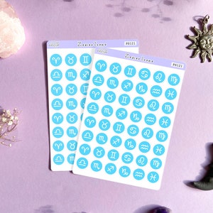 May include: Two sheets of stickers with blue circles featuring white zodiac signs. The sheets are labeled "Zodiac Icons" and "PS121".