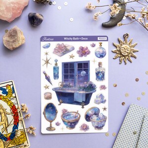 Puede incluir: Una hoja de pegatinas con un tema de ba&ntilde;o de bruja. Las pegatinas incluyen una ba&ntilde;era, una ventana con un cielo nocturno estrellado, un espejo, un cuenco de agua y varios otros art&iacute;culos de bruja. Las pegatinas est&aacute;n impresas en papel blanco y tienen un acabado brillante. La hoja est&aacute; etiquetada como "Witchy Bath + Deco" y "PS533".