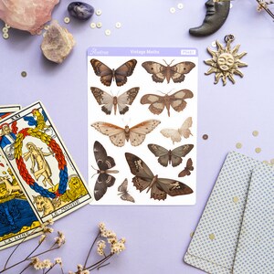 May include: A sheet of vintage moth stickers with a white background and a purple border. The stickers feature detailed illustrations of various moths in shades of brown, black, and white. The sheet is labeled "Vintage Moths" and "PS461".