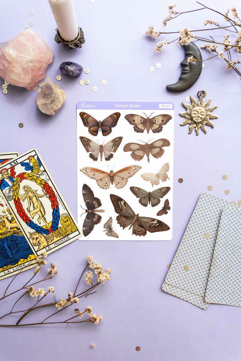 May include: A sheet of vintage moth stickers with a white background and a purple border. The stickers feature detailed illustrations of various moths in shades of brown, black, and white. The sheet is labeled "Vintage Moths" and "PS461".