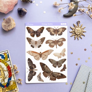 May include: A sheet of vintage moth stickers with a white background and brown and beige moths. The sheet is labeled "Vintage Moths" and "Astrae" with the product number "PS461".