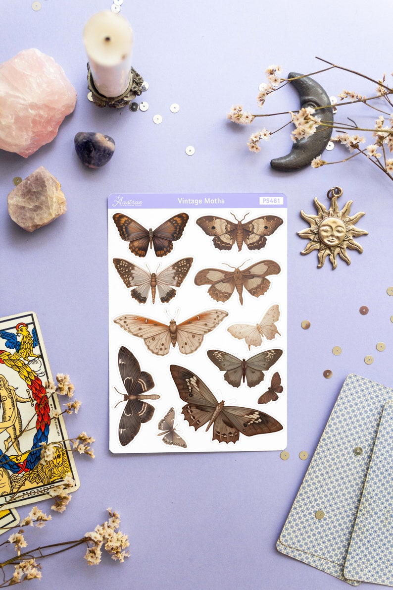 May include: A sheet of vintage moth stickers with a white background and brown and beige moths. The sheet is labeled "Vintage Moths" and "Astrae" with the product number "PS461".