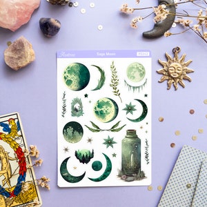 Puede incluir: Una hoja de pegatinas con un esquema de color verde y blanco con varias fases lunares, estrellas e ilustraciones bot&aacute;nicas. La hoja de pegatinas est&aacute; etiquetada como "Sage Moon" y "PS242".