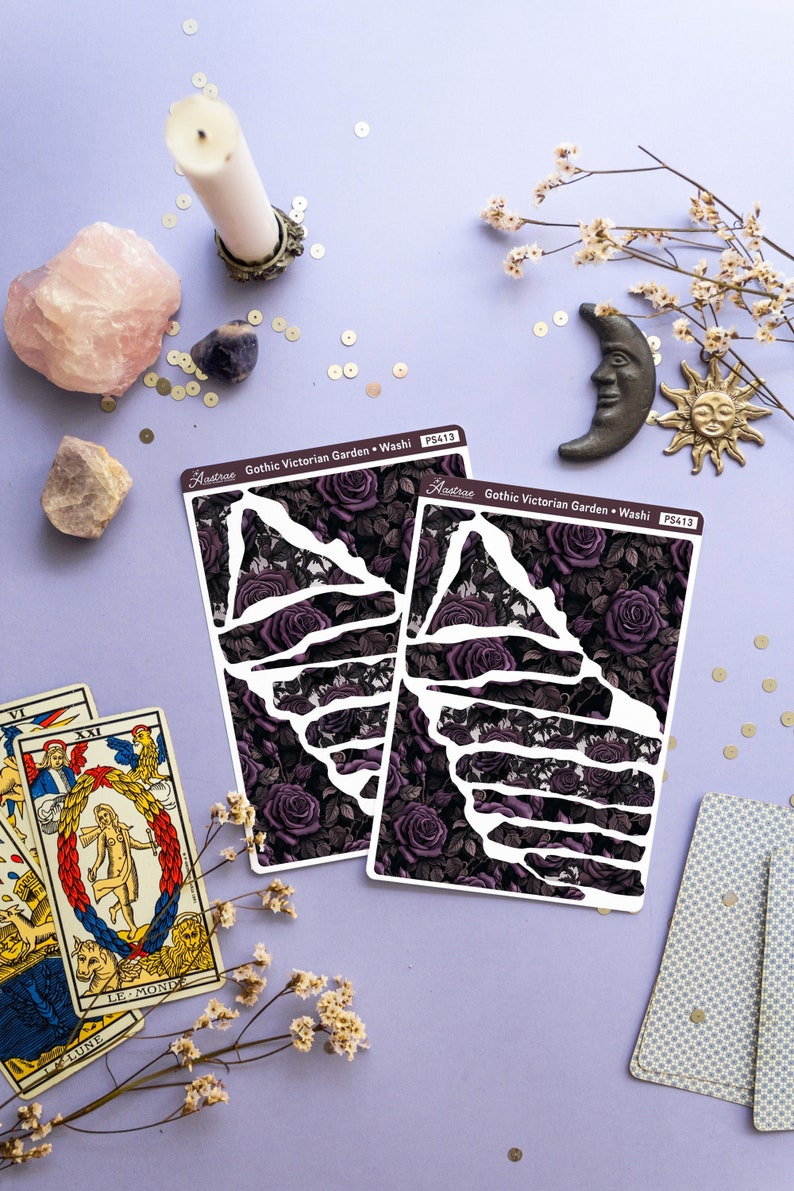 May include: Two sheets of decorative washi tape with a gothic Victorian garden design. The tape features a dark purple and black floral pattern with a white outline. The text "Aastrae Gothic Victorian Garden Washi P5413" is printed on each sheet.