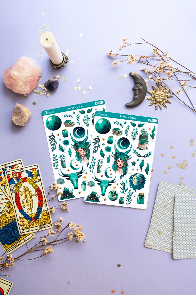 May include: Two sheets of stickers featuring a green and gold design with a celestial theme. The stickers include a woman with green hair and horns, a bull, a crescent moon, stars, and a jar. The text on the stickers reads "Taurus + Deco" and "Astroee" with the number "PS211".