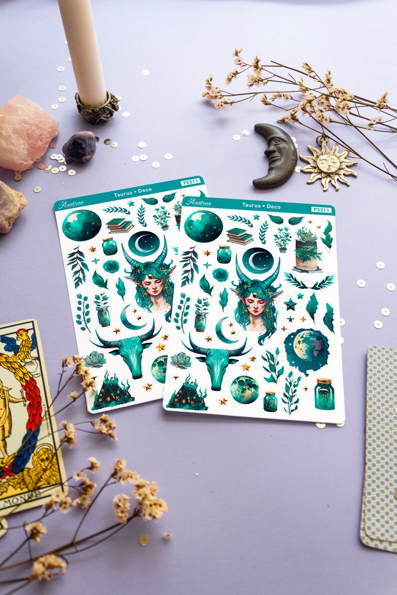 May include: Two sheets of stickers featuring a green and gold Taurus zodiac theme. The stickers include a bull, a woman with green hair, a crescent moon, stars, and plants. The sheets are labelled "Taurus + Deco" and "Hastrae" with the product number "PS211".