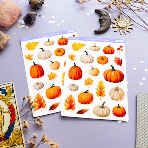May include: Two sheets of stickers featuring fall pumpkins and leaves. The stickers are white with a light blue border and the text "Fall Pumpkins & Leaves" printed in black. The stickers are on a light purple surface.