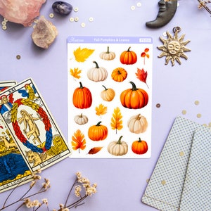 May include: A sheet of stickers featuring fall-themed illustrations of pumpkins and leaves. The stickers are on a white background and have a light blue border. The text "Fall Pumpkins & Leaves" is printed on the sheet. The stickers are arranged in a grid pattern.
