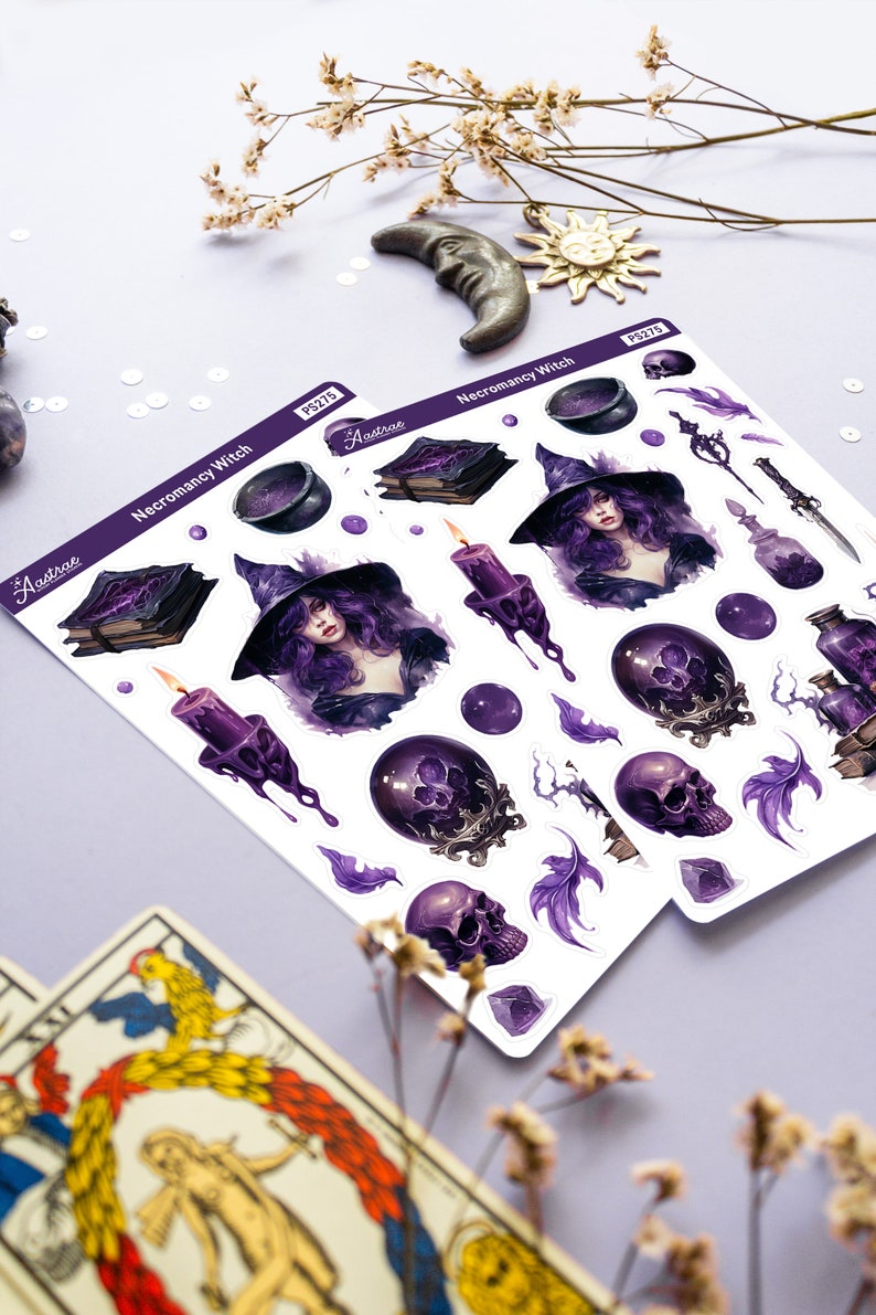 May include: A sheet of stickers featuring a purple and black necromancy witch with a cauldron, books, candles, skulls, and feathers. The stickers are labelled "Necromancy Witch" and "Aastroe PS215".