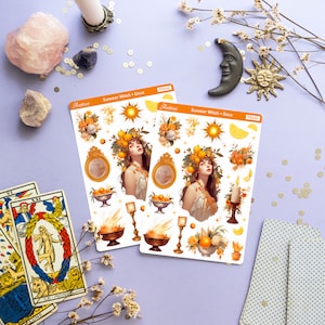 May include: Two sheets of stickers featuring a summer witch theme. The stickers are white with illustrations of a woman with a crown of lemons, a sun, lemons, flowers, candles, and bowls of fruit. The text on the stickers reads "Summer Witch + Deco" and "Aestrive".