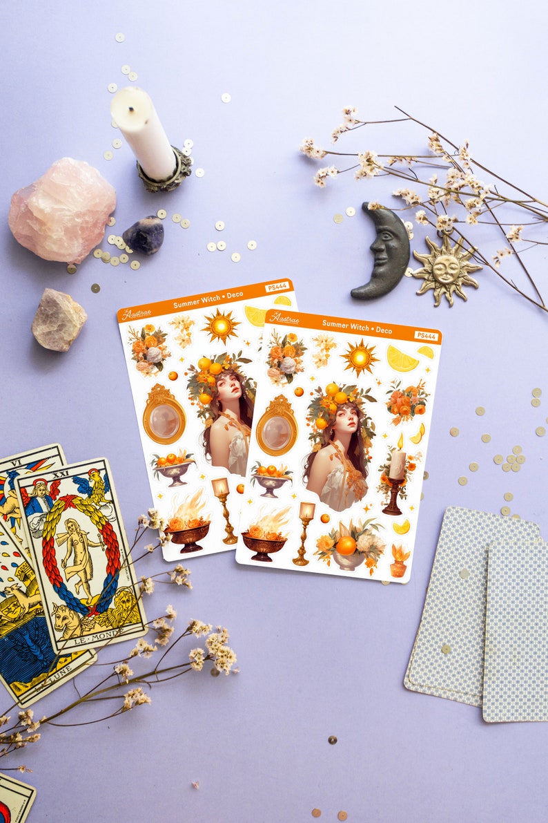 May include: Two sheets of stickers featuring a summer witch theme. The stickers are white with illustrations of a woman with a crown of lemons, a sun, lemons, flowers, candles, and bowls of fruit. The text on the stickers reads "Summer Witch + Deco" and "Aestrive".