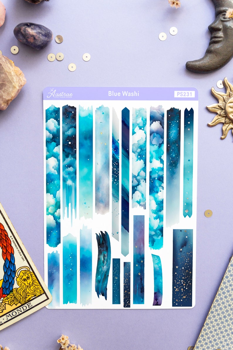 May include: A sheet of blue washi tape with a variety of designs, including clouds, stars, and galaxy patterns. The sheet is labeled "Blue Washi" and "PS231".