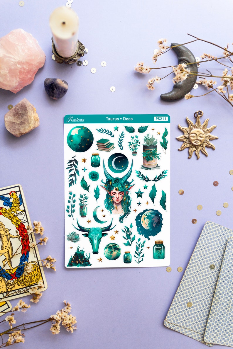 May include: A sheet of stickers featuring a green and gold Taurus zodiac sign, a woman with green hair and horns, a crescent moon, stars, and plants. The sticker sheet is labelled "Taurus Deco" and "PS211".