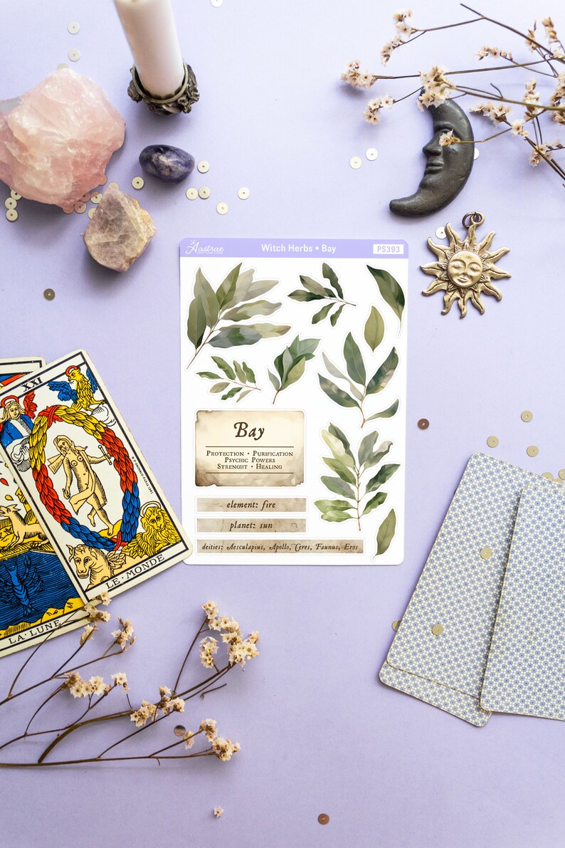 May include: A sheet of stickers featuring illustrations of bay leaves and text about the herb's properties. The text reads "Witch Herbs - Bay", "Bay", "Protection - Purification - Psychic Powers - Strength - Healing", "element: fire", "planet: sun", and "deities: Aesculapius, Apollo, Ceres, Faunus, Eros".