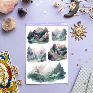 May include: A sheet of stickers featuring four watercolor illustrations of misty mountains with a pink and green color scheme. The stickers are labeled "Mystic Mountains" and "PS371".