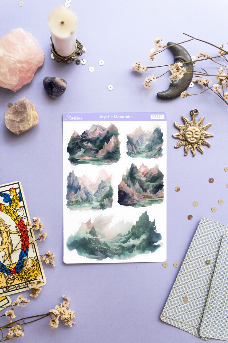 May include: A sheet of stickers featuring four watercolor illustrations of misty mountains with a pink and green color scheme. The stickers are labeled "Mystic Mountains" and "PS371".