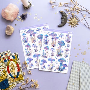 Puede incluir: Dos hojas de pegatinas de setas iridiscentes con un dise&ntilde;o de acuarela. Las pegatinas est&aacute;n sobre un fondo morado con otros elementos decorativos, como cartas del tarot, cristales y una vela.