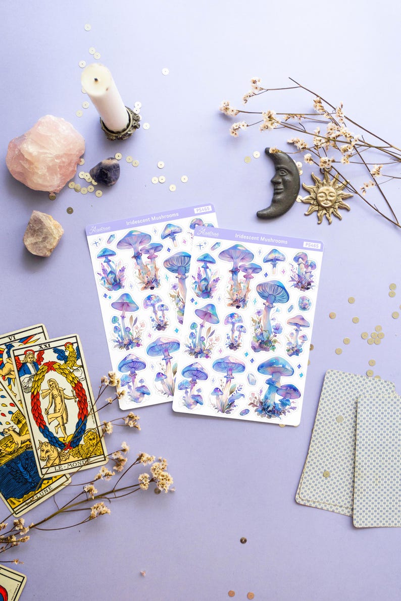 Puede incluir: Dos hojas de pegatinas de setas iridiscentes con un dise&ntilde;o de acuarela. Las pegatinas est&aacute;n sobre un fondo morado con otros elementos decorativos, como cartas del tarot, cristales y una vela.