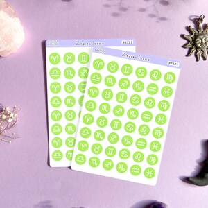 May include: Two sheets of green and white sticker paper with a variety of zodiac symbols. The stickers are in a circle shape with a white outline and a green background. The text "Zodiac Icons" is printed on the top of each sheet.
