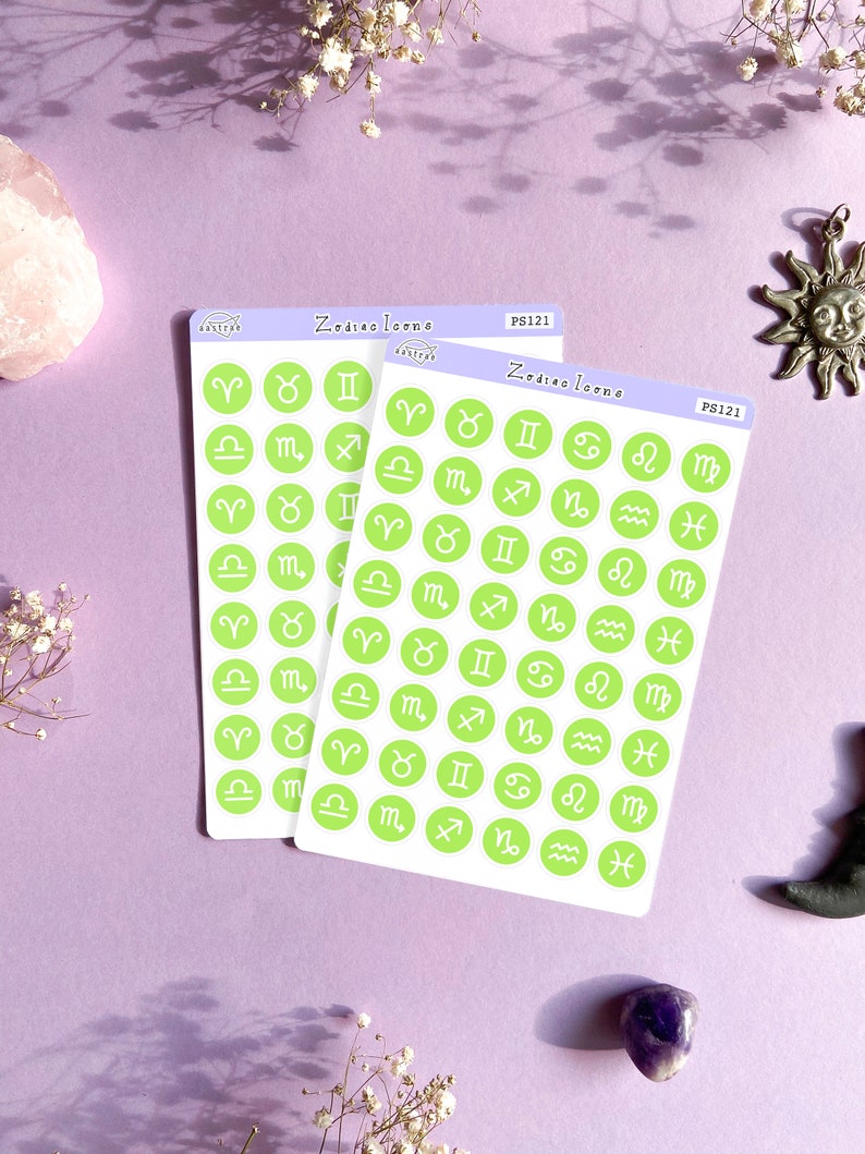 May include: Two sheets of green and white sticker paper with a variety of zodiac symbols. The stickers are in a circle shape with a white outline and a green background. The text "Zodiac Icons" is printed on the top of each sheet.