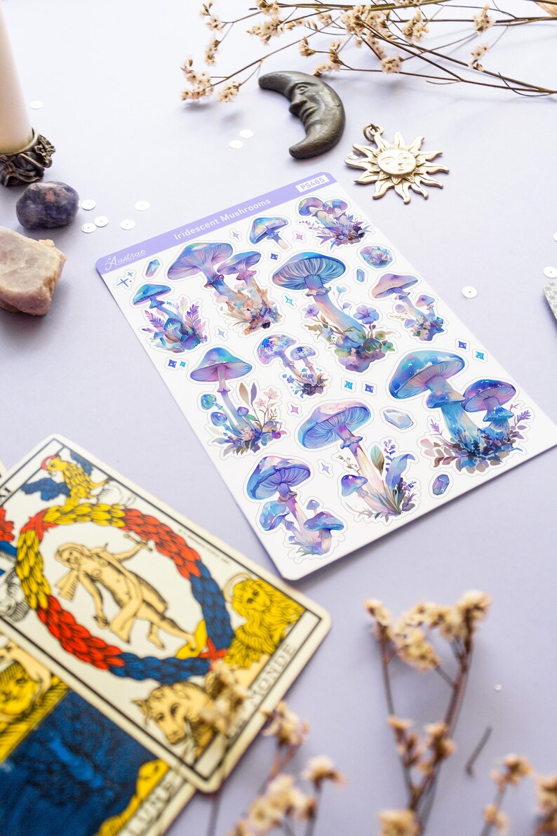 Puede incluir: Una hoja de pegatinas de setas iridiscentes con fondo blanco. Las pegatinas son en tonos azules, morados y rosas. La hoja est&aacute; etiquetada como "Iridescent Mushrooms" y tiene una peque&ntilde;a pegatina con el n&uacute;mero "P3465".