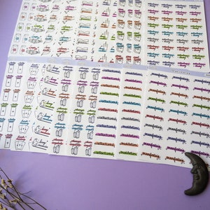 May include: A set of colorful sticker sheets with various designs and phrases related to witchcraft and spirituality. The stickers feature words like "cleanse", "crystals", "intentions", "manifestations", "meditation", "daily card", "spell", "astrology", and "tarot".