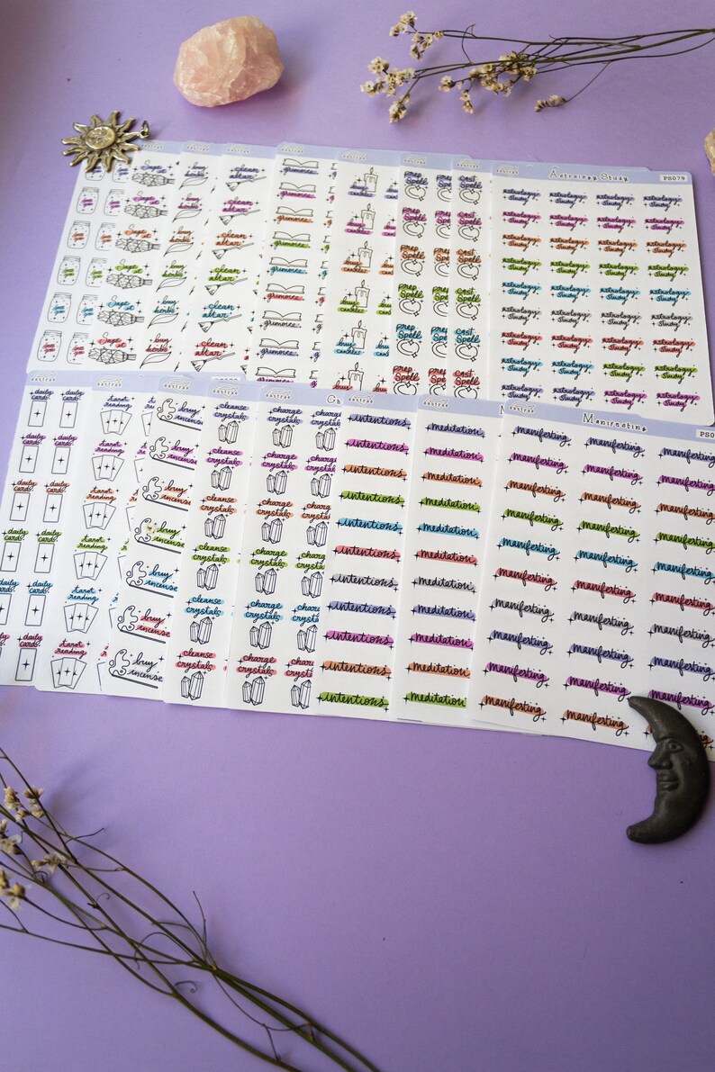 May include: A set of colorful sticker sheets with various designs and phrases related to witchcraft and spirituality. The stickers feature words like "cleanse", "crystals", "intentions", "manifestations", "meditation", "daily card", "spell", "astrology", and "tarot".