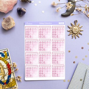 Op de afbeelding: Een vel met galaxy-kalender stickers met een roze en witte gradi&euml;nt. De stickers zijn gerangschikt in een raster van vier rijen en drie kolommen. De stickers zijn gelabeld met "Galaxy Calendars" en "PS263".
