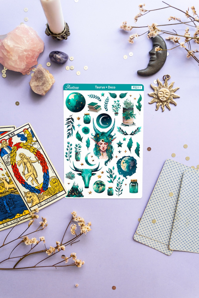 May include: A sheet of stickers featuring a green and gold design with a variety of images, including a woman with green hair, a bull, a crescent moon, stars, and jars. The sheet is labelled "Astrae Taurus Deco PS211".