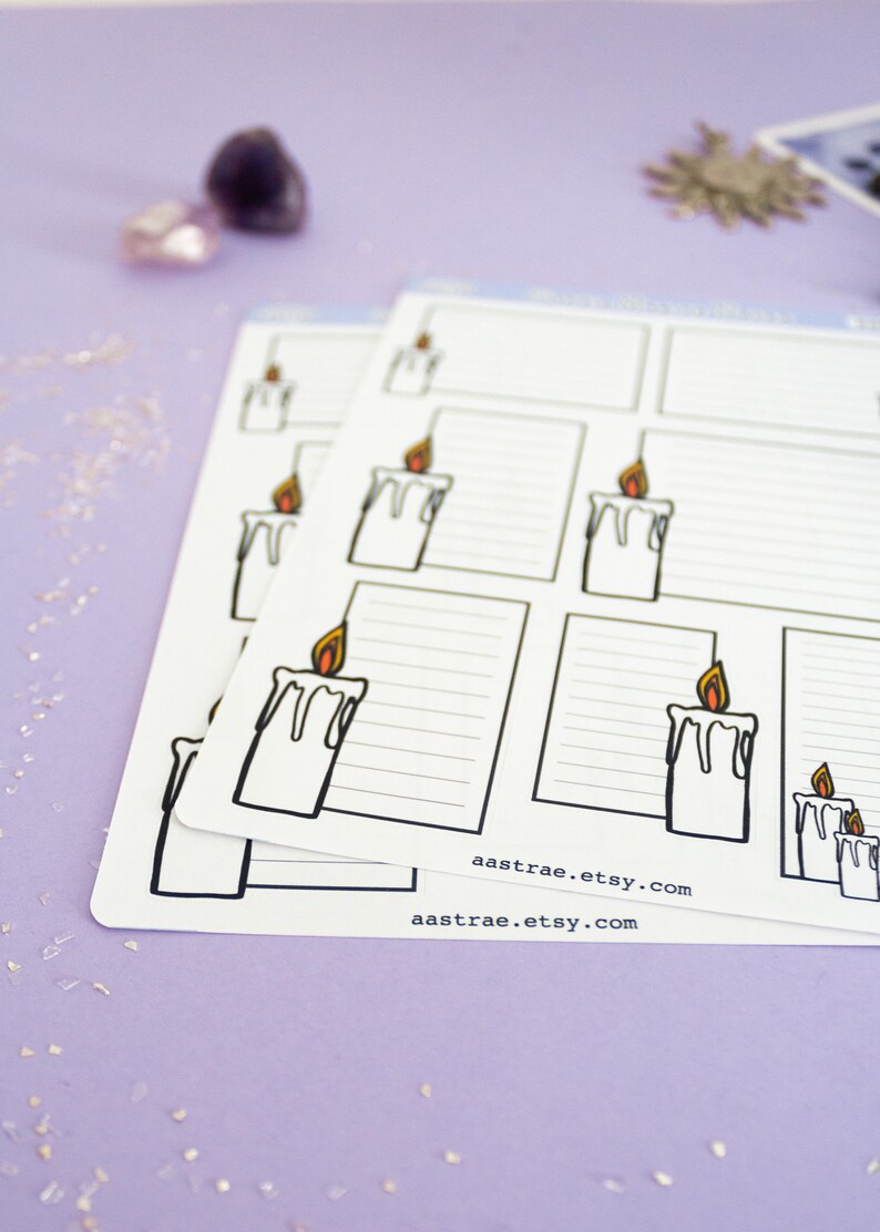 May include: A set of printable planner stickers featuring a candle with a flame. The stickers are white with black outlines and have a lined area for writing. The stickers are on a purple background with glitter.