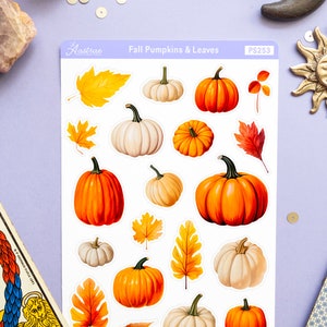 May include: A sheet of stickers featuring fall-themed pumpkins and leaves. The stickers are white with a variety of orange, white, and brown pumpkins and leaves. The sheet is labeled "Fall Pumpkins & Leaves" and "PS253".
