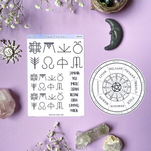 May include: A set of stickers featuring pagan symbols and the names of the eight pagan festivals: Yule, Imbolc, Ostara, Beltane, Litha, Lammas, Mabon, and Samhain. The stickers are on a white background with a light blue border. The stickers are surrounded by various crystals and flowers on a purple background.