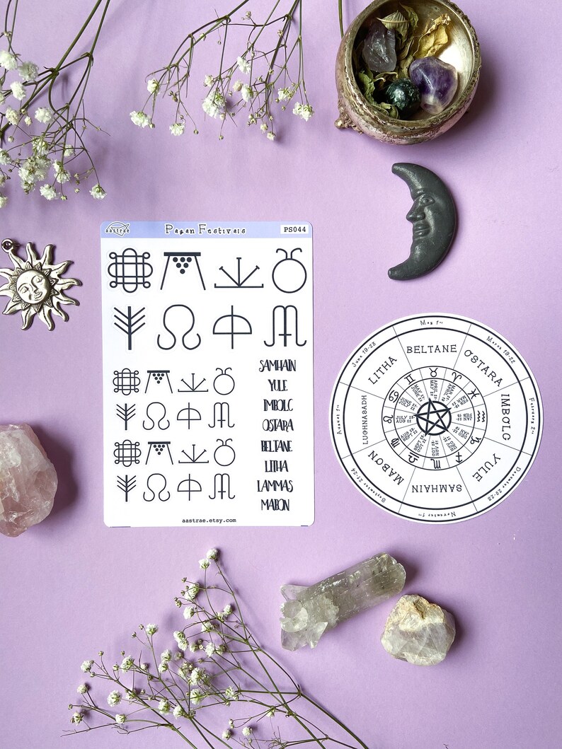 May include: A set of stickers featuring pagan symbols and the names of the eight pagan festivals: Yule, Imbolc, Ostara, Beltane, Litha, Lammas, Mabon, and Samhain. The stickers are on a white background with a light blue border. The stickers are surrounded by various crystals and flowers on a purple background.