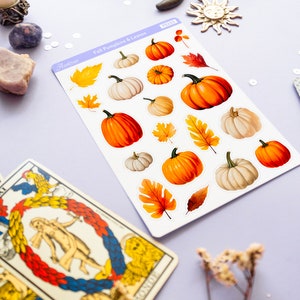 May include: A sheet of stickers featuring fall-themed pumpkins and leaves. The stickers are white with a light blue border and the text "Fall Pumpkins & Leaves" in black. The stickers are arranged in rows and include various sizes and colors of pumpkins and leaves.