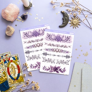 Peut inclure: Deux feuilles d'autocollants de s&eacute;parateurs floraux victoriens avec des motifs floraux violets et gris. Les autocollants sont sur un fond violet clair avec une carte de tarot, une bougie, des cristaux et une petite figurine de soleil et de lune.