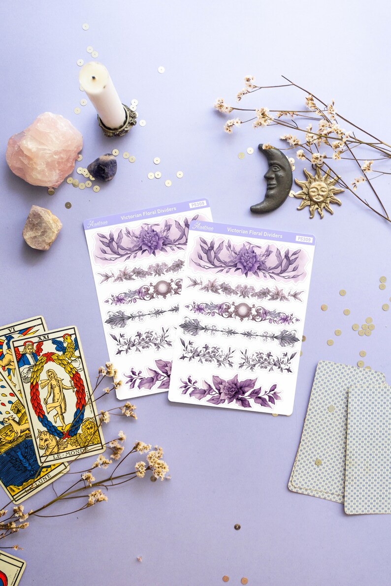 Peut inclure: Deux feuilles d'autocollants de s&eacute;parateurs floraux victoriens avec des motifs floraux violets et gris. Les autocollants sont sur un fond violet clair avec une carte de tarot, une bougie, des cristaux et une petite figurine de soleil et de lune.