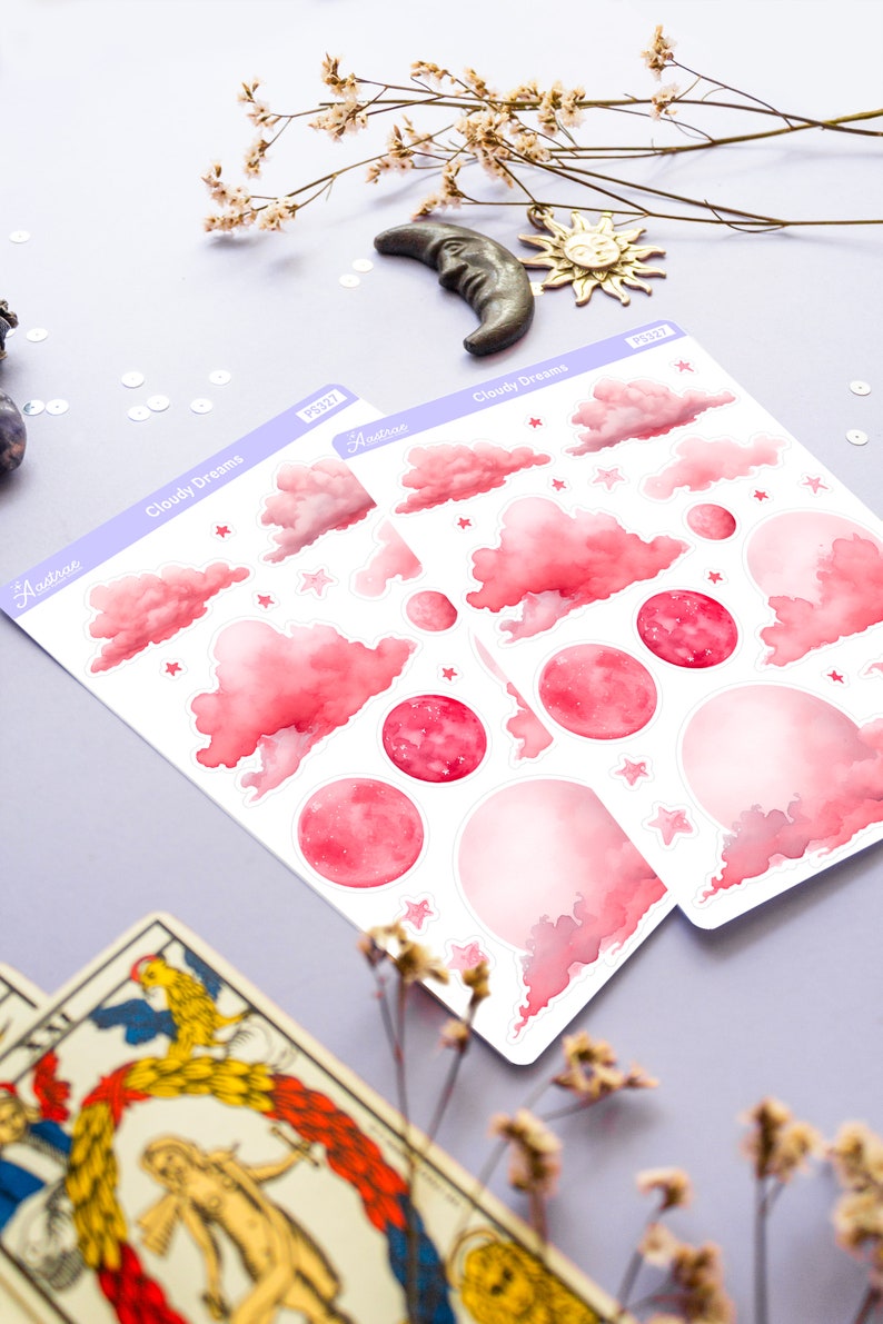 May include: Two sheets of pink and white stickers with a watercolor design of clouds, stars, and moons. The stickers are labeled "Cloudy Dreams" and "Astrotae".