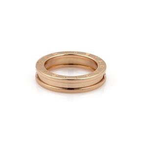 May include: A rose gold ring with a double-band design. The outer band features engraved lettering. The ring is set against a white background, highlighting its polished surface and circular shape. A luxury jewelry item.