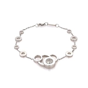 May include: A silver bracelet featuring a series of circular links connected by a delicate chain. The bracelet has a unique design with multiple circles clustered together, and a small, clear stone is visible in one of the larger circles.