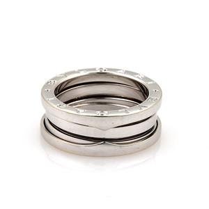 May include: A silver-colored ring with a stacked design. The ring features three bands, with the top band displaying engraved details. The bands are smooth and have a polished finish. The ring is set against a white background.