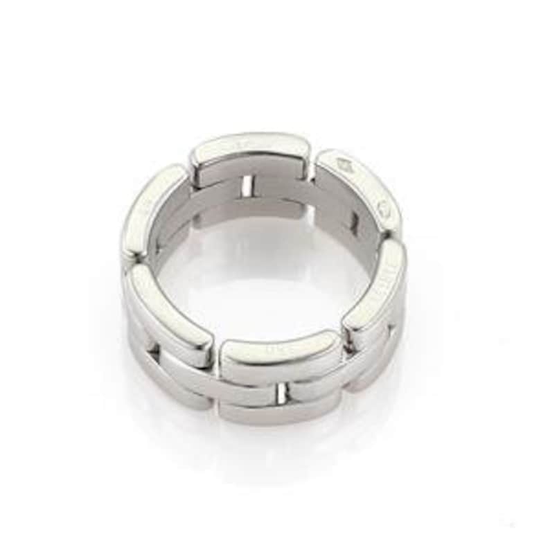 May include: A silver Cartier Juste un Clou ring with a linked chain design. The ring is made of polished metal and has a smooth, rounded surface.