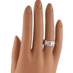May include: A silver wedding band with a textured, linked design. The band is made of metal and has a polished finish.