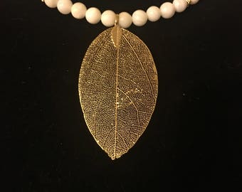 White beaded gold leaf shaped pendant